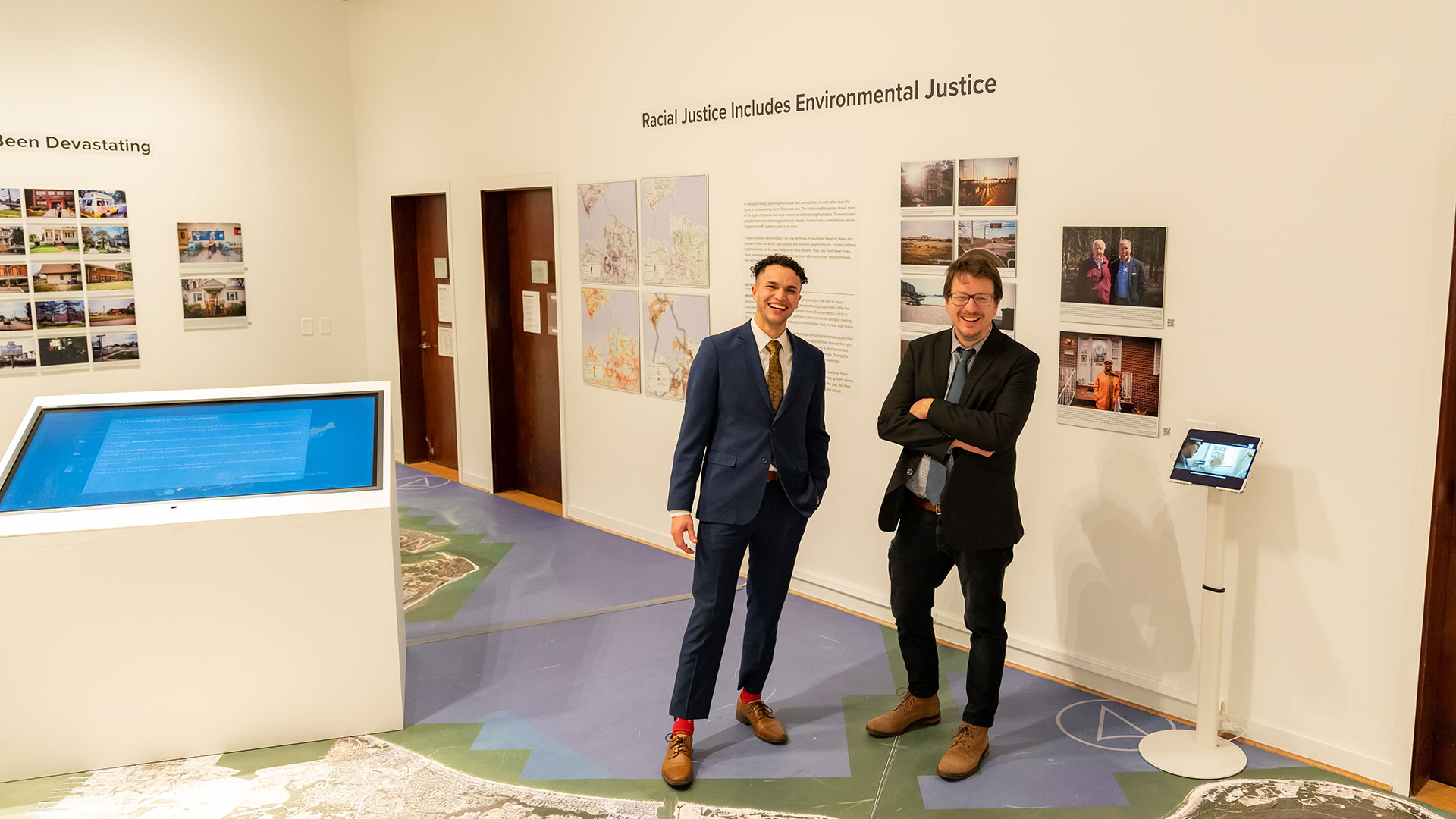 Professor John Finn and student showing their social inequality exhibit